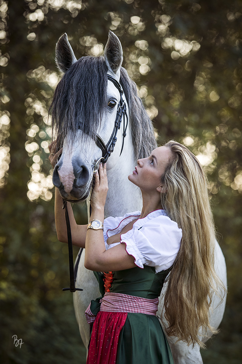 Pferdefotografie bei München: Frau im Dirndl mit PRE-Hengst
