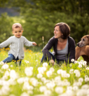 Familienfotografie Bayern: Mutter mit Kleinkind und Hund in Blumenwiese